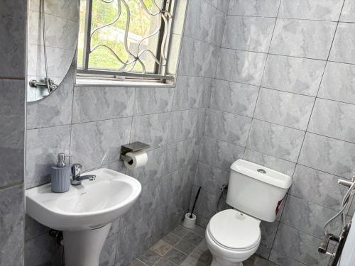 a bathroom with a toilet and a sink at Dutus Hotel Entebbe in Wakiso