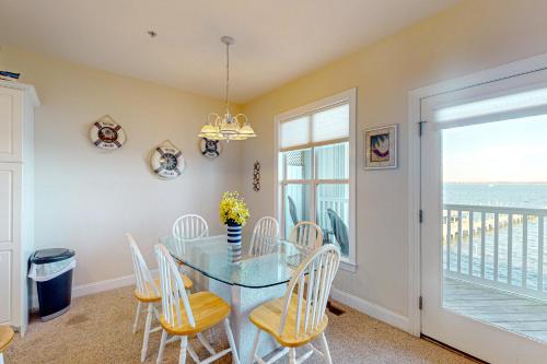 a dining room with a glass table and chairs at Peace on the sound, fun on the Beach in Indian Beach