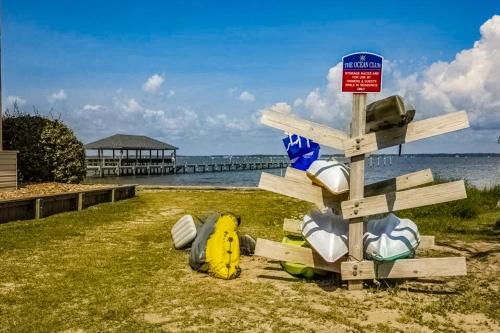 a sign on the side of a beach with bags at Peace on the sound, fun on the Beach in Indian Beach