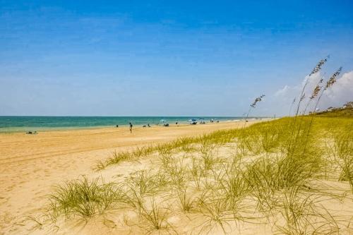 a sandy beach with people and the ocean in the background at Peace on the sound, fun on the Beach in Indian Beach