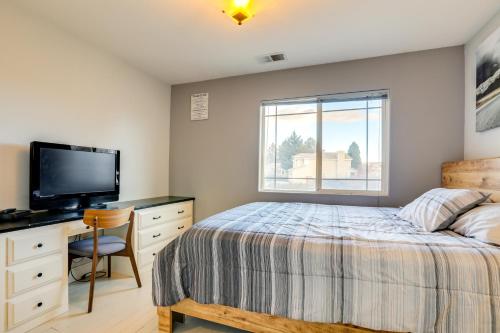 a bedroom with a bed and a desk and a television at Mtn-View Escape with Hot Tub in Sparks! in Sparks