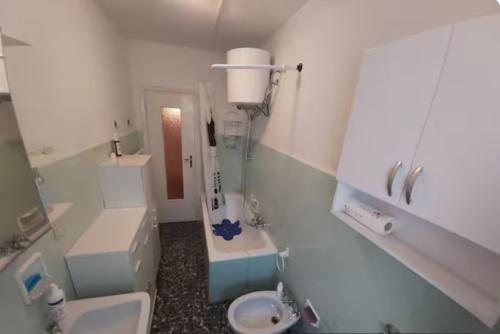 a white bathroom with a sink and a toilet at Appartamento immerso nel verde vista panoramica in Pragelato