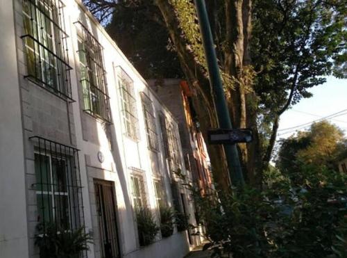a building with windows and a pole in front of it at Departamento Rompecabezas SúperAnfitrión Coyoacan in Mexico City