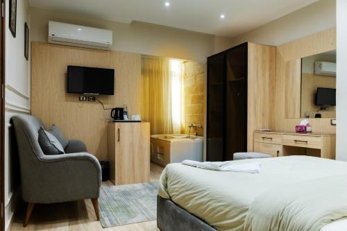 a hotel room with a bed and a chair at Mirage pyramids view hotel in Cairo