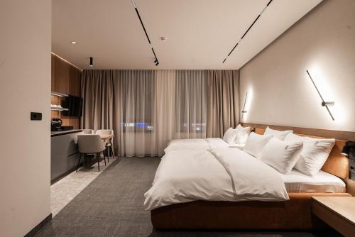 a hotel room with a large bed and a kitchen at Garni Hotel Galeria in Banja Luka
