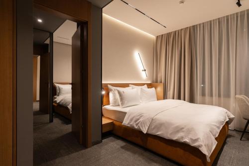 a hotel room with a bed and a mirror at Garni Hotel Galeria in Banja Luka