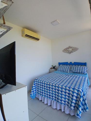 a bedroom with a bed and a flat screen tv at Casa Contêiner imersão com Natureza Floresta Sapiranga-5km praia do forte in Mata de Sao Joao