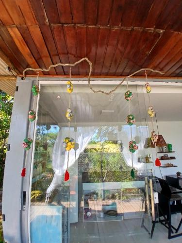 a porch with christmas ornaments hanging from the ceiling at Casa Contêiner imersão com Natureza Floresta Sapiranga-5km praia do forte in Mata de Sao Joao
