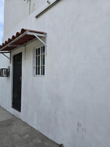 a white building with a door and a window at Loft Iteso Buganvilias Coca Cola Periferico y Lopez Mateos in Guadalajara