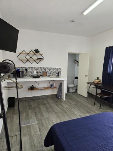a room with a room with a bed and a table at Loft Iteso Buganvilias Coca Cola Periferico y Lopez Mateos in Guadalajara