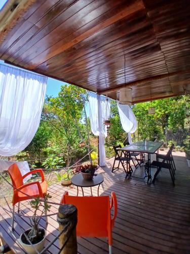 a wooden deck with tables and chairs on it at Casa Contêiner imersão com Natureza Floresta Sapiranga-5km praia do forte in Mata de Sao Joao