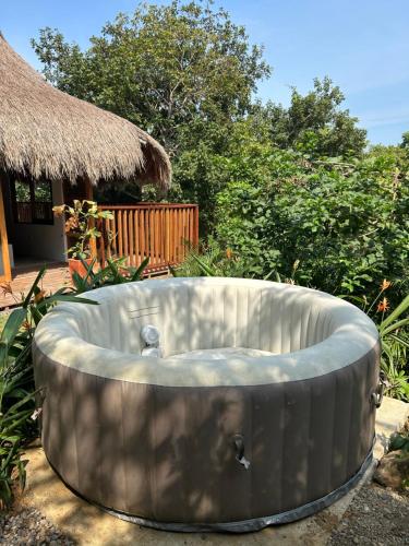 a bath tub in a yard with a hut at Kamajorú Ecohabitat in Tubará