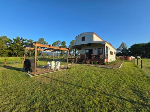 a house with a gazebo and chairs in a yard at Clandulla Cottages & Farmstay in Boyland