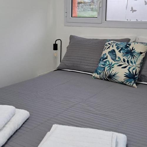 a bedroom with a bed with a blue and white pillow at Monoambiente Neli in Villa Pehuenia
