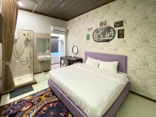 a bedroom with a large bed and a bathroom at Duck House Hostel & Resort Khon Kaen in Ban Pet