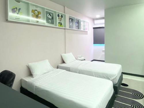 a room with two beds and a chair in it at Duck House Hostel & Resort Khon Kaen in Ban Pet