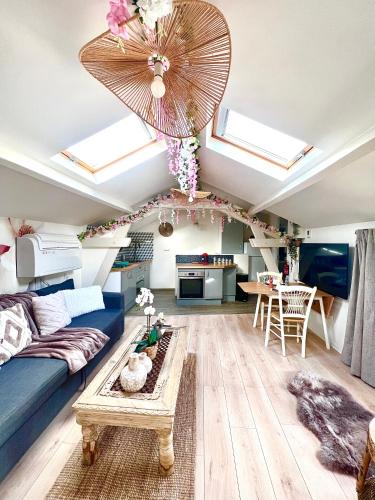 un salon avec un canapé bleu et un plafond avec des fenêtres dans l'établissement Boho chic apartment with terraces 10min from Paris, à Vitry-sur-Seine