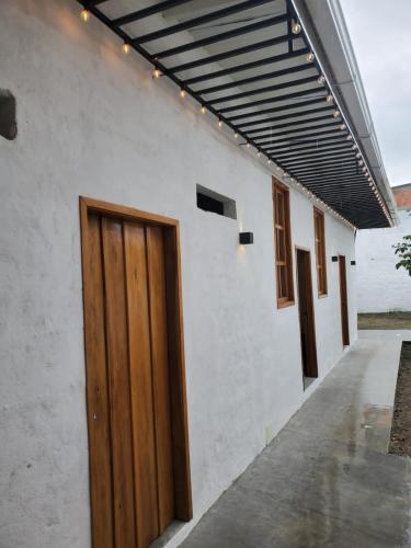 a white building with a wooden door on it at Casa del Cable in Mariquita