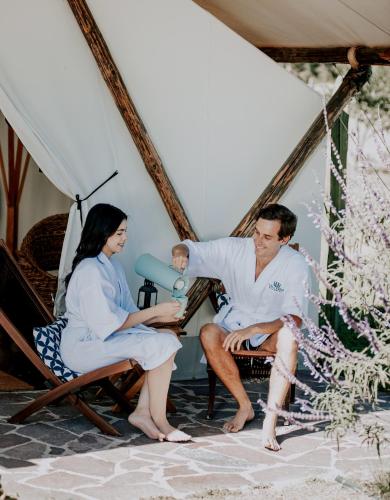 a man and a woman sitting in chairs with a baby at Salterra Glamping in Tequisquiapan