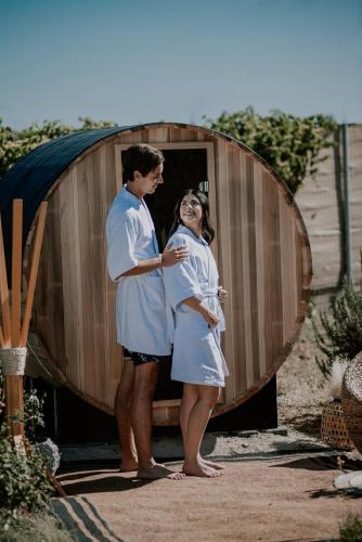 a man and woman standing in front of a wooden barrel at Salterra Glamping in Tequisquiapan