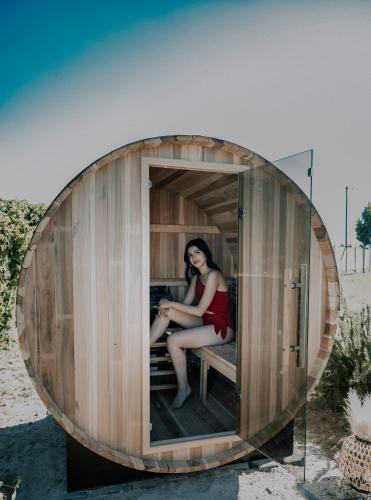 a woman in a red dress sitting in a small wooden building at Salterra Glamping in Tequisquiapan