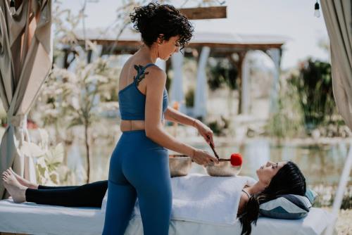 a woman in a blue outfit is cutting an apple at Salterra Glamping in Tequisquiapan