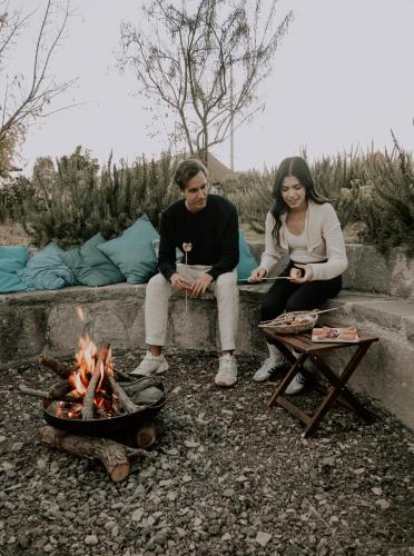 a man and a woman sitting next to a fire at Salterra Glamping in Tequisquiapan