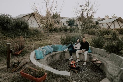two people sitting on a couch in a yard at Salterra Glamping in Tequisquiapan