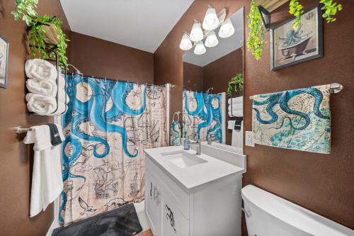 a bathroom with a sink and a shower curtain at Steampunk Haven in the Heart of Tacoma! in Tacoma