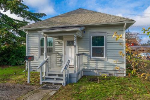 a small white house with a porch and stairs at Steampunk Haven in the Heart of Tacoma! in Tacoma