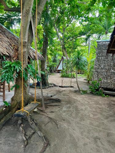 a swing hanging from a tree in a resort at Georgia's Neverland Hostel in Malapascua Island