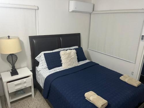 カロライナにあるShalex House 2のベッドルーム1室(青いベッド1台、ランプ付きのナイトスタンド付)