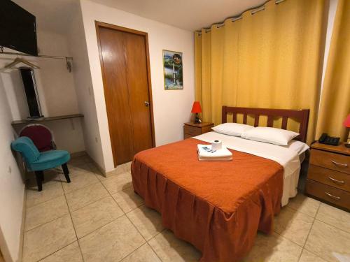 a hotel room with a bed and a chair at El Paraíso de Lunahuaná in Lunahuaná