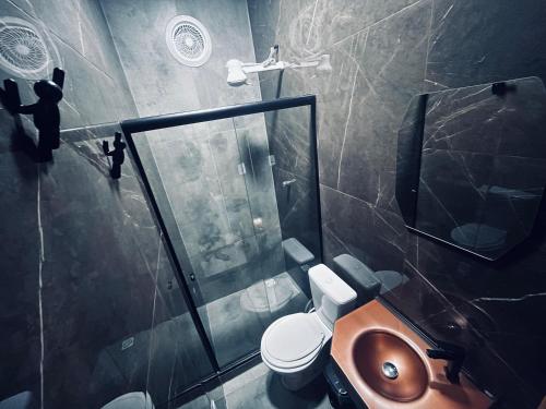 een badkamer met toilet en glazen douche bij Meu Loft Barra Nova 2 in Saquarema