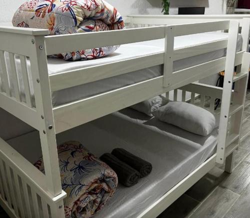 een wit stapelbed met een kussen op de onderste plank bij Meu Loft Barra Nova 2 in Saquarema