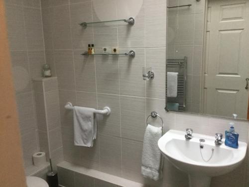 a bathroom with a sink and a toilet and a mirror at Watts Lodge in Bicester