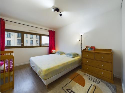 une chambre avec un lit, une commode et une fenêtre dans l'établissement Roi de la Seine à Paris, stade, Gare parking et terrasse, à Saint-Denis