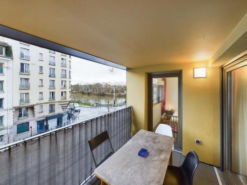 un balcon avec une table et une vue sur une ville dans l'établissement Roi de la Seine à Paris, stade, Gare parking et terrasse, à Saint-Denis