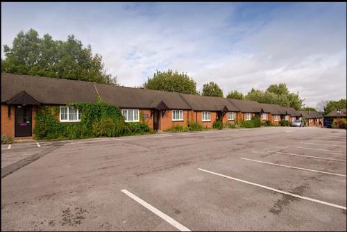 an empty parking lot in front of a motel at Tyger Inn Derby in Derby