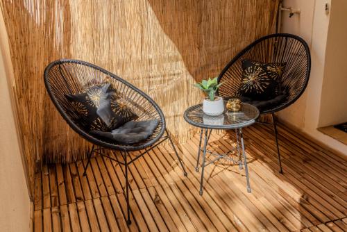two chairs and a table in front of a wall at La Suite Tentation in Cannes