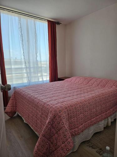 una camera da letto con un letto rosa e una finestra di Bordemar las cruces a San Antonio