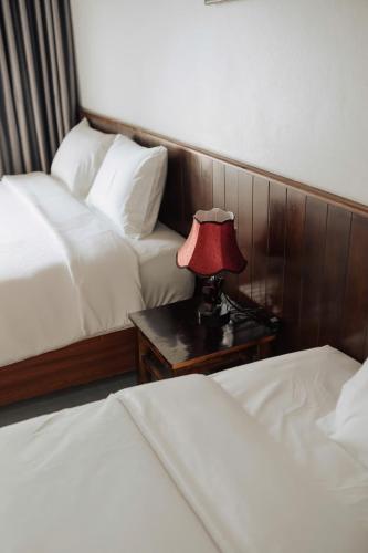 a bedroom with two beds and a red lamp on a table at TamCoc Peaceful Homestay in Vũ Lâm