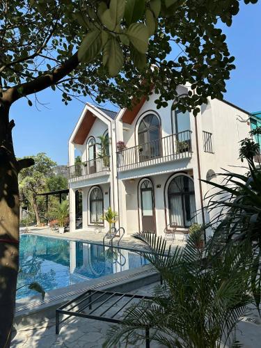 a large white house with a swimming pool at TamCoc Peaceful Homestay in Vũ Lâm