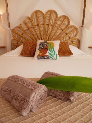 a bedroom with a bed with a wooden headboard at Coco Soley in Le Diamant