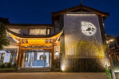 a building with a sign on it at night at 清舍雪山观景设计师民宿 in Lijiang