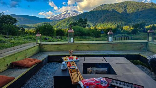 a patio with a table and a view of a mountain at Confortable refugio de monataña con vista al Volcan in Malalcahuello