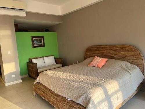 una camera da letto con un letto grande e una sedia di Apartment with sea view a Cozumel