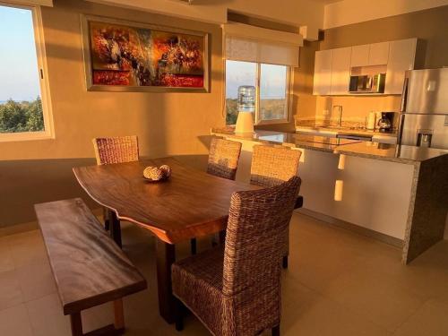 a kitchen and dining room with a wooden table and chairs at Apartment with sea view in Cozumel