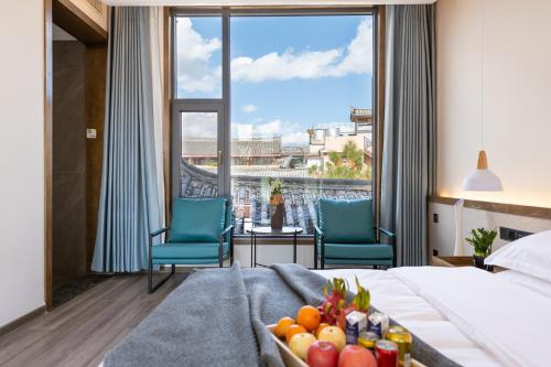 a hotel room with a bed and a large window at 清舍雪山观景设计师民宿 in Lijiang