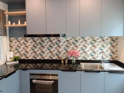 a kitchen with white cabinets and a sink at Sirihouse at Supalai Bella Thalang Phuket in Phuket